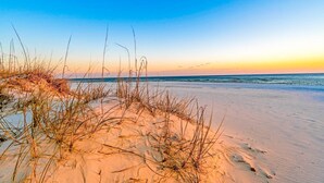 A beach with sand dunes and sparse vegetation. - Remodeled, lagoon-front home with decks, views, paddleboat (Gulf Shores)