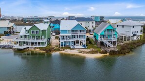 A coastal residential area with houses featuring balconies and waterfront views. - Remodeled, lagoon-front home with decks, views, paddleboat (Gulf Shores)