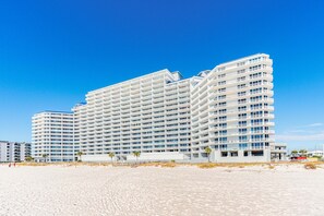 A multi-story hotel with a modern design, located on a beach with a clear blue sky. - Corner Condo w Amazing Gulf-Front Views, Balcony & Shared Pools, Hot Tubs, & Gym (Gulf Shores)