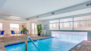 An indoor swimming pool with clear blue water, surrounded by lounge chairs and potted plants. - Gulf-Front, 12th-Floor Condo w Great View, Balcony, AC & Shared Pools Hot Tubs (Gulf Shores)
