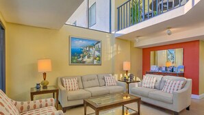 A living room with two sofas, a coffee table, and a painting on the wall.