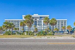 A multi-story hotel with a modern design, featuring balconies and a central courtyard with palm trees. - Breezy Condo near the Beach w/Balcony, A/C, Shared Pool, Tennis, Hot Tub, WiFi (Gulf Shores)