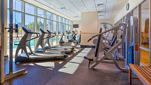 A gym with treadmills, weight machines, and a bench. - Gulf-view condo with pool, hot tub, lazy river & balcony (Gulf Shores)