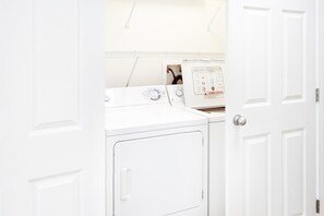 A laundry room with two white washing machines and a dryer. - Gulf-Front Retreat Perfect For Couples w/Shared Pool & Hot Tub, Free WiFi, & W/D (Gulf Shores)