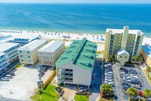 A hotel with a parking lot, a beach view, and a pool. - Darling Beach Condo w a Loft, Free WiFi, Balcony, Shared Pool, & Beach Access (Gulf Shores)