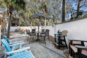 Eine Außenpatio mit Pool, Liegestühlen und einem Tisch mit Stühlen.