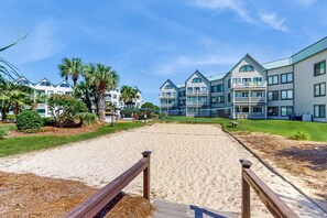 A beach with a wooden walkway leading to a building with multiple balconies and a clear blue sky. - 3rd-floor Gulf-view condo with hot tub, outdoor pool, tennis, balcony, elevator (Gulf Shores)