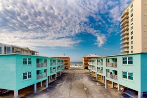 A beachfront hotel with multiple floors, balconies, and a view of the ocean. - Cheerful beach stay with heated pool, balcony, gulf views, W&D, & central AC (Gulf Shores)