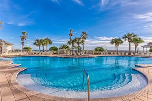 A large outdoor swimming pool with palm trees, lounge chairs, and a clear blue sky. - The Beach Club 401C, Beachfront condo in Gulf Shores with pools, tennis, gym and Clubhouse Membership! (Gulf Shores)