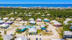 Un quartier résidentiel situé sur la côte, avec des maisons, une piscine et une vue sur l’océan.