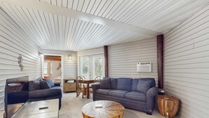 A modern living room with a sofa, coffee table, and TV stand. - Downstairs duplex near the beach with full kitchen, WiFi, cable, partial AC (Gulf Shores)