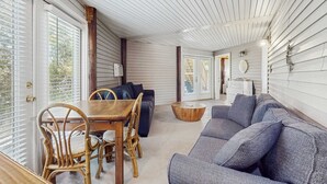 A room with a dining table, chairs, a sofa, and a wooden coffee table. - Downstairs duplex near the beach with full kitchen, WiFi, cable, partial AC (Gulf Shores)