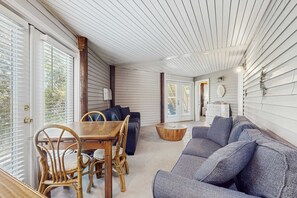 Ein Zimmer mit Esstisch, Stühlen, einer Couch und einem Holztisch.