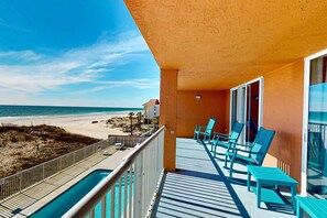 Ein Balkon mit Pool, Meerblick und Sitzgelegenheit im Freien.