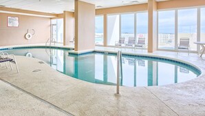 Ein Hallenbad mit freiem Blick auf die Stadtkulisse durch große Fenster.