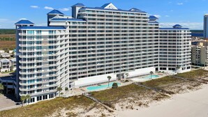 Et stort, moderne hotel med flere etager, med altaner, et poolområde og beliggenhed ved stranden.