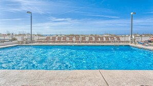 A swimming pool with lounge chairs and a view of the beach. - 5th-Floor Beach View Condo w/Balcony, Shared Pool, Outdoor Shower, A/C, WiFi (Gulf Shores)