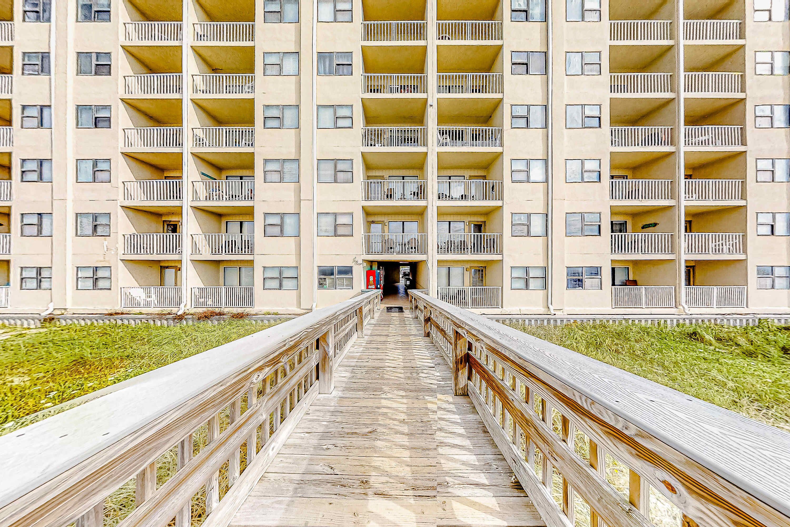 A multi-story building with balconies and a central walkway.