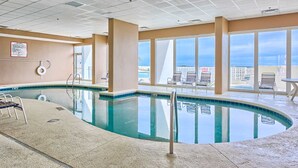 An indoor swimming pool with clear views of the city skyline through large windows. - Gulf-Front Condo w Shaded Balcony, WiFi, AC & Shared Pools, Hot Tubs & Sauna (Gulf Shores)