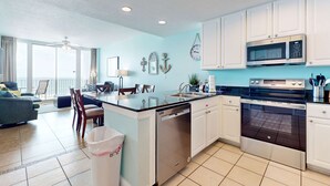 A modern kitchen with white cabinets, a built-in microwave, and a dishwasher. - Gulf-Front Condo w Big Beach Views, Balcony, WiFi & Shared Pools, Hot Tubs & Gym (Gulf Shores)