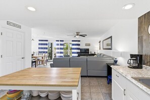 A modern kitchen with a wooden dining table, a built-in oven, and a coffee maker. - Incredible 2 bed 2 bath condo by the beach in Indian Shores (Indian Shores)