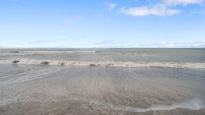 Een strand met zachte golven en een heldere lucht.