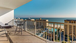 Ein Balkon mit Meerblick, ein Pool und ein Gebäude mit Balkonen.