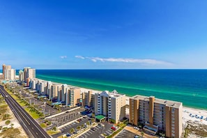 A coastal hotel with multiple floors, a parking lot, and a beach view. - Gorgeous Gulf view condo with indoor,outdoor pools, hot tubs, gym, & balconies (Gulf Shores)