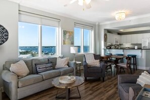 A living room with a sofa, armchairs, a coffee table, and a view of the ocean. - Gorgeous Gulf view condo with indoor,outdoor pools, hot tubs, gym, & balconies (Gulf Shores)