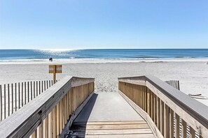 A wooden boardwalk leading to a beach with a clear sky. - Beachfront retreat with outdoor pool, gulf views, & W/D - perfect for long stays (Gulf Shores)