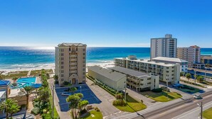 A coastal hotel with a pool, beachfront view, and multiple buildings. - Gulf view condo with 2 pools, lazy river, hot tub, sauna, gym & beach access (Gulf Shores)