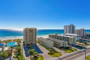 A coastal hotel with a pool, beachfront view, and multiple buildings. - Gulf view condo with 2 pools, lazy river, hot tub, sauna, gym & beach access (Gulf Shores)