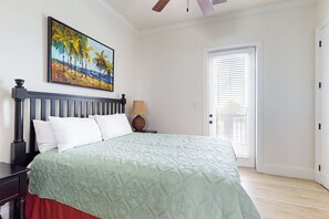 Ein Schlafzimmer mit Bett, Gemälde, Tür und Nachttisch.