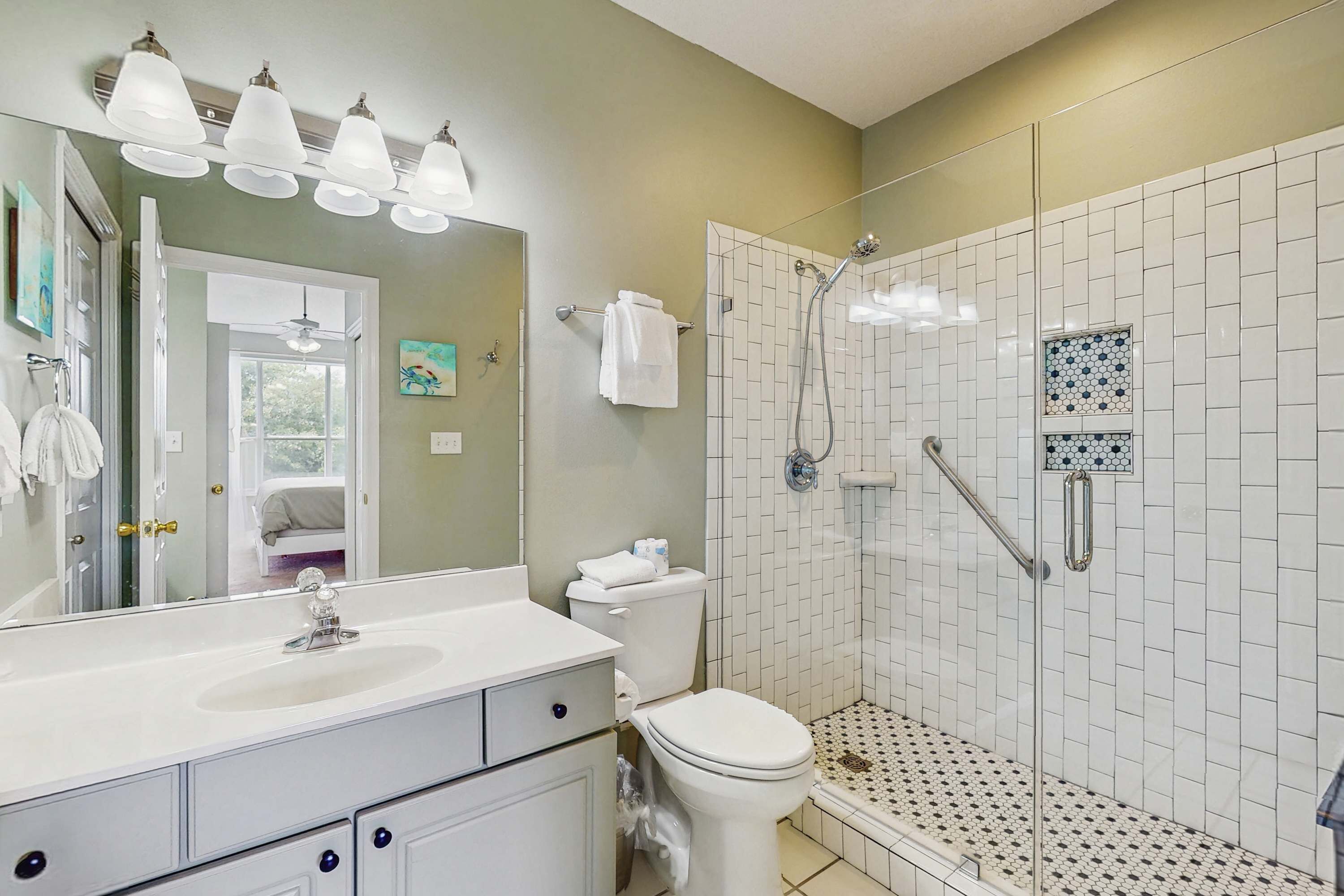 Een badkamer met een wit wastafel, toilet, douche met glazen deur en een betegelde vloer.