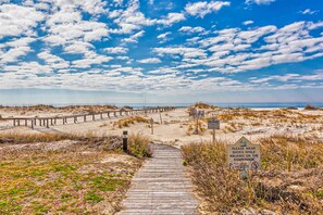 A wooden boardwalk leading to a beach with a sign advising to wear shoes. - Gulf-view condo with 4 pools, hot tubs, beach access, central AC, & washer/dryer (Gulf Shores)