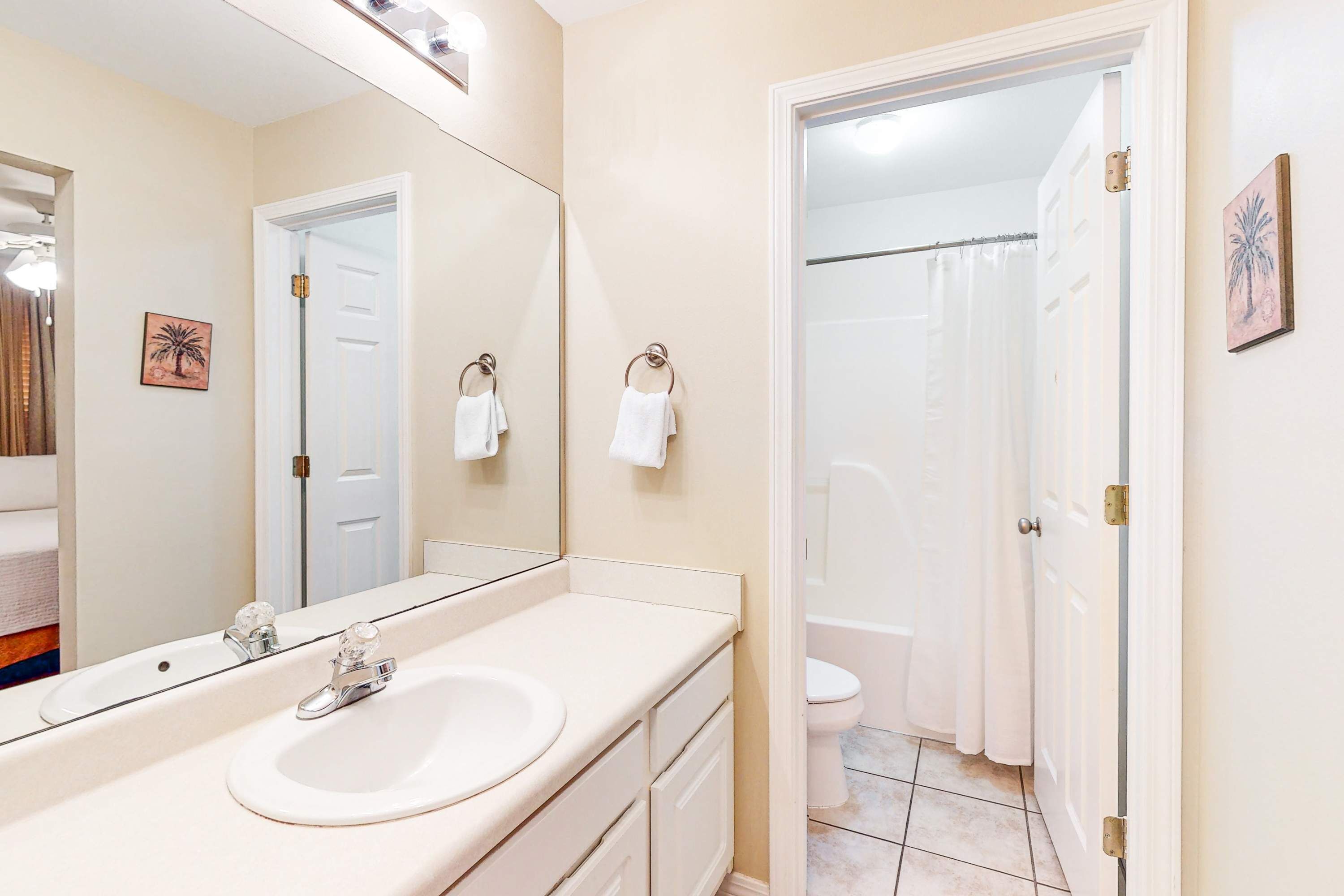 Une salle de bain avec un lavabo, un miroir et des toilettes.