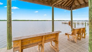 Een houten terras met banken, met uitzicht op een rustig wateroppervlak.