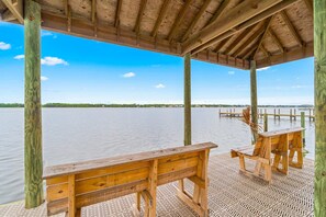 Eine Holzterrasse mit Bänken mit Blick auf ruhiges Wasser.