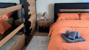 Ett sovrum med en våningssäng, ett nattduksbord med en lampa och en liten matta.