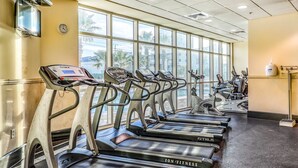 A gym with multiple treadmills, a digital display, and large windows. - Corner condo with Gulf lagoon views, beach access & pools lazy river (Gulf Shores)