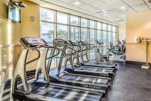 A gym with multiple treadmills, a digital display, and large windows. - Corner condo with Gulf lagoon views, beach access & pools lazy river (Gulf Shores)