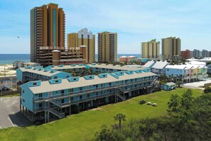 A hotel with multiple floors, a swimming pool, and a view of the beach. - Waterfront condo with a furnished balcony, peek-a-boo Gulf views, & shared pools (Gulf Shores)