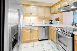 A kitchen with stainless steel appliances, wooden cabinets, a dishwasher, and an oven. - 6th-Floor waterfront condo with pool & balcony - snowbird-friendly (Gulf Shores)