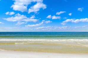 Ein Strand mit blauem Himmel und Meereswellen.