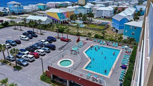 Ett semesterhotell med en swimmingpool, en parkeringsplats och färgglada byggnader.