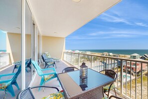 A balcony with a glass table, chairs, and a lantern. - Waterfront condo with pool, piers & breathtaking balcony views (Gulf Shores)
