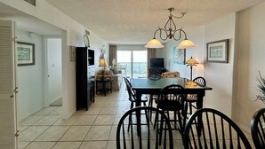 A dining area with a table, chairs, and pendant lights. - 6th-floor beach-view condo with outdoor pool, tennis court, sauna, hot tub, gym (Gulf Shores)