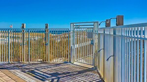 Eine Holzterrasse mit Metallgeländern und einem weißen Zaun.
