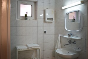 A bathroom with a window, a towel rack, a sink, a mirror, and a wall-mounted heater. - Holiday Homes With a Terrace, Close to the Beach (Ustka)