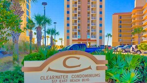 Naamplaatje voor Clearwater Condominiums, met een helder zicht op de architectuur van het gebouw en de omliggende begroeiing.